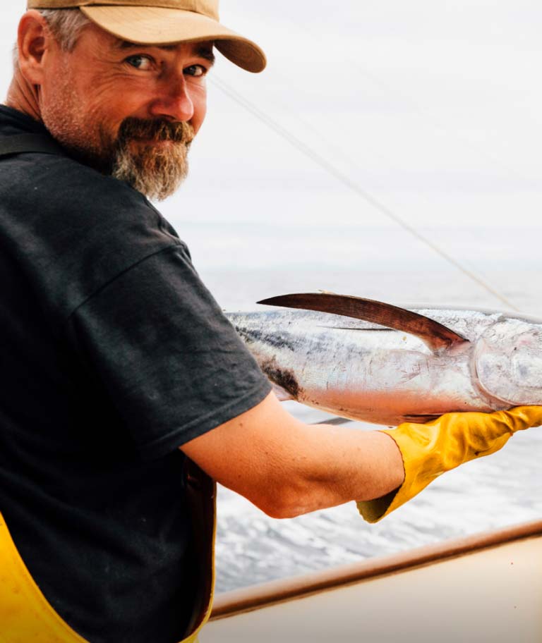 A smiling fisherman holding a catch