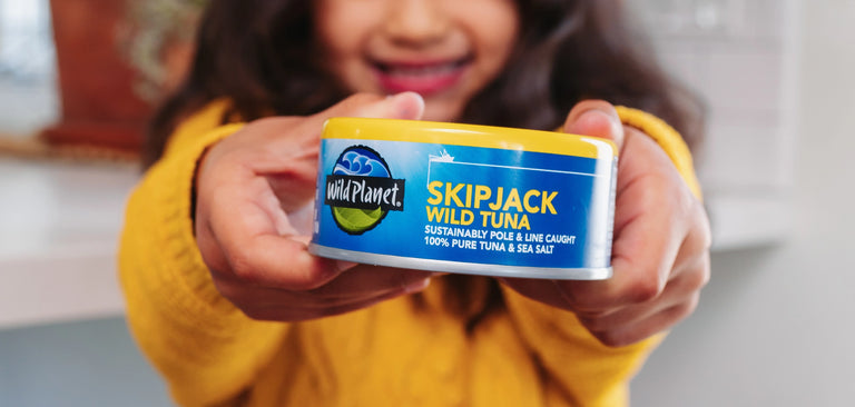 Girl holding Wild Planet Skipjack Wild Tuna