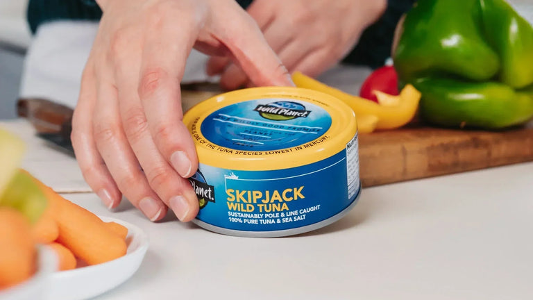 5 Things to Know About Eating Seafood During Pregnancy: Woman holding can of Wild Planet Skipjack Wild Tuna in kitchen setting